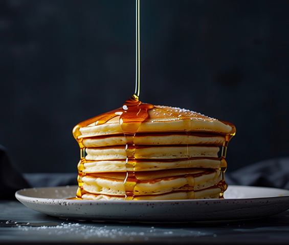 a stack of pancakes topped with Canadian maple syrup
