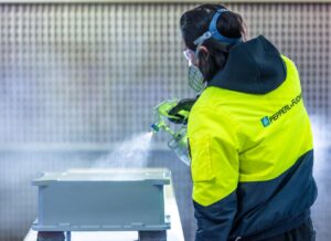 Mitarbeiter bei Lackierarbeiten an Gehäuse